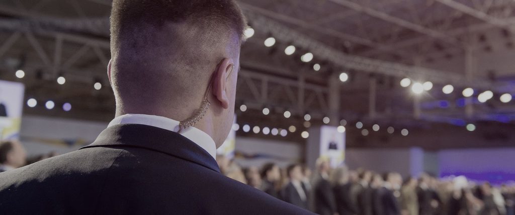 Bodyguard wearing an earpiece at a crowded event